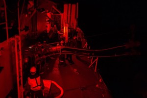 Under red light sailors in Her Majesty’s Canadian Ship (HMCS) Toronto conducts a night time Replenishment At Sea (RAS) with the French Supply Ship A630 Marne on October 20, 2014 during Operation REASSURANCE in the Mediterranean Sea. RCN Photo. (HS2014-A158-014)