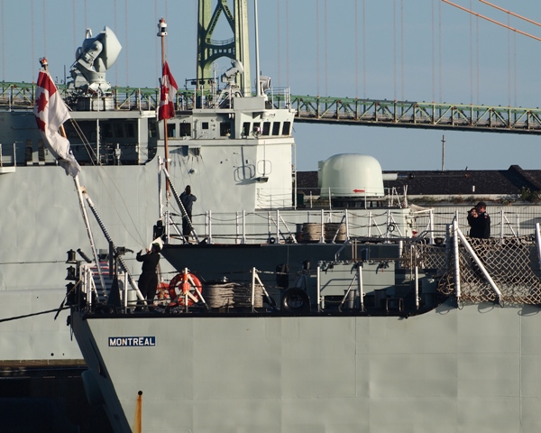 HMCShips MONTREAL and CHARLOTTETOWN raise the RCN Ensign and Jack during morning Colours while at HMC Dockyard, Halifax on 5 September 2015. Decommissioned RCN destroyer, HMCS IROQUOIS is in the background.

Roger Litwiller collection, courtesy Roger Litwiller. (RTL53627)