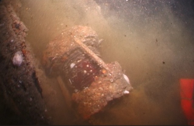 Screen shot from a 2018 dive video of HMCS TRENTONIAN's port navigation lamp, lying on the wreck.